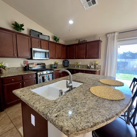 a bathroom with a granite countertop sink and a shower