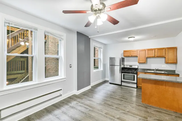 a kitchen with a refrigerator cabinets and wooden floor