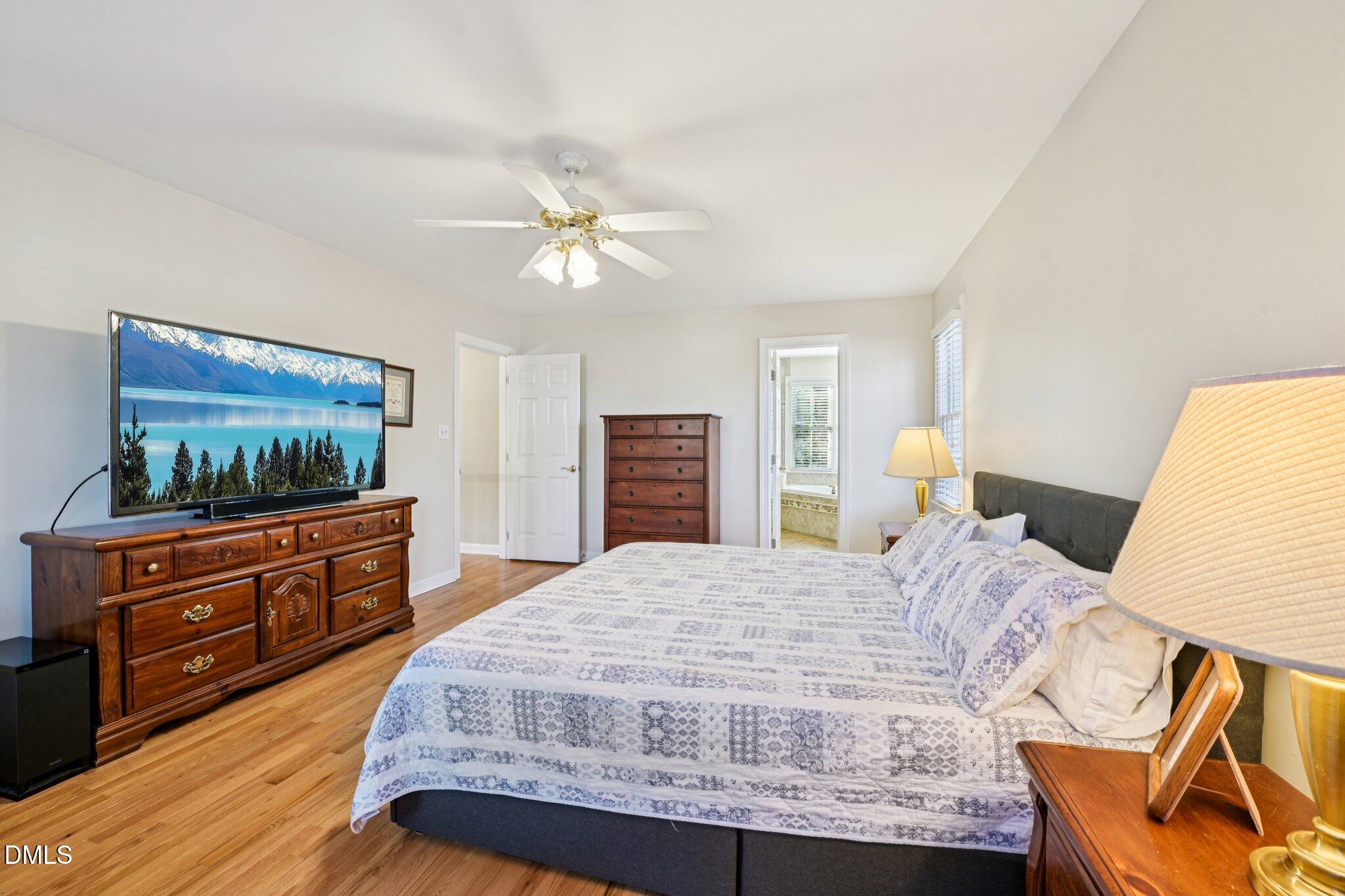 200 Ridge Creek Drive Morrisville, NC 27560 - Photo 22 of 38 a bedroom with a bed and a dresser with wooden floor