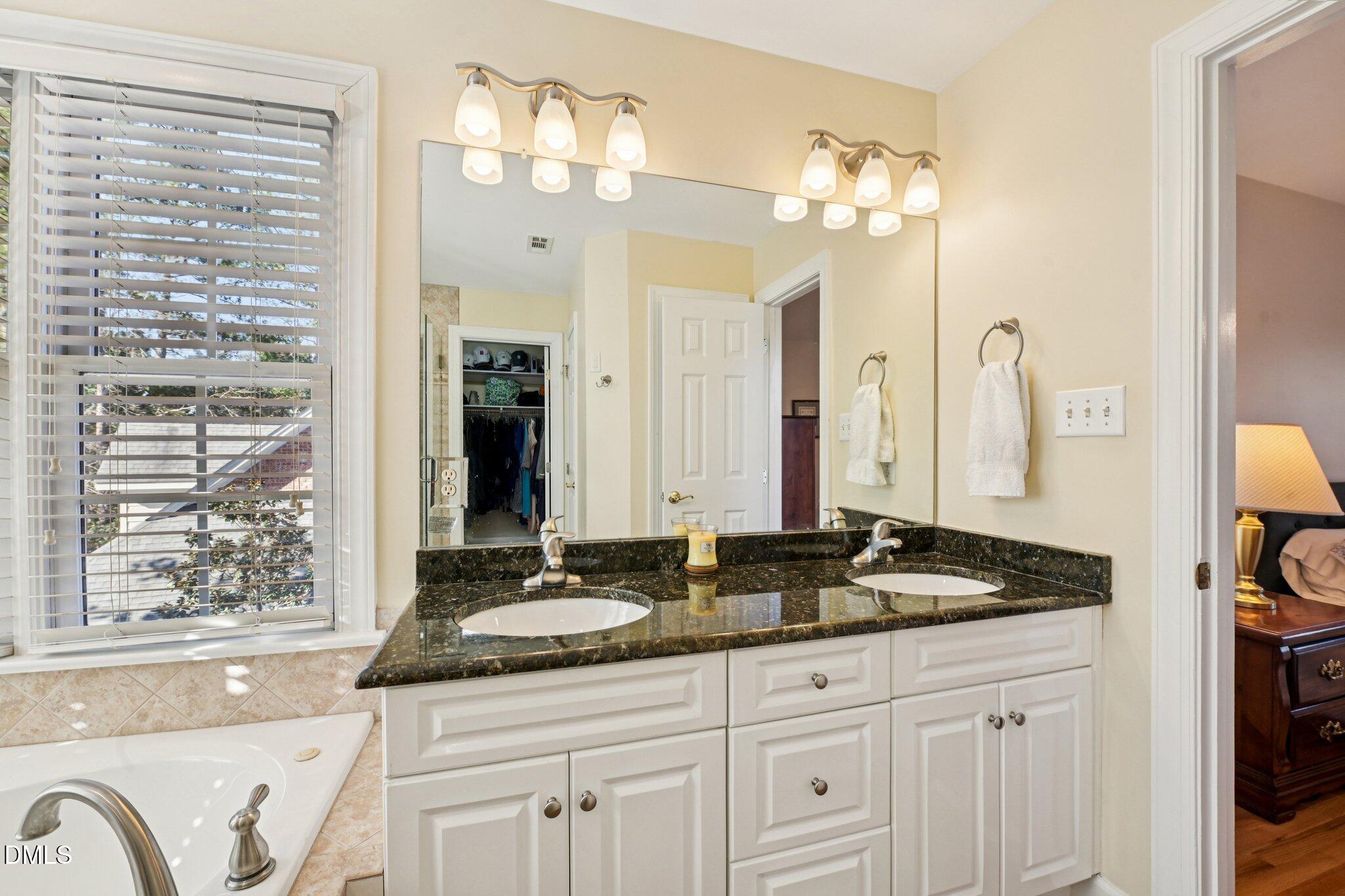 200 Ridge Creek Drive Morrisville, NC 27560 - Photo 23 of 38 a bathroom with a granite countertop sink a large mirror and a shower