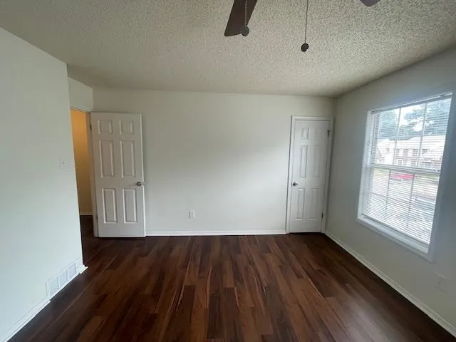 a view of empty room with wooden floor