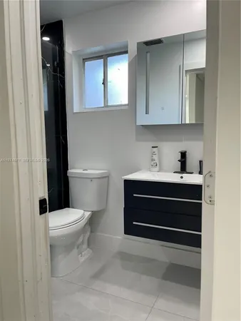 a bathroom with a sink a toilet a mirror and shower