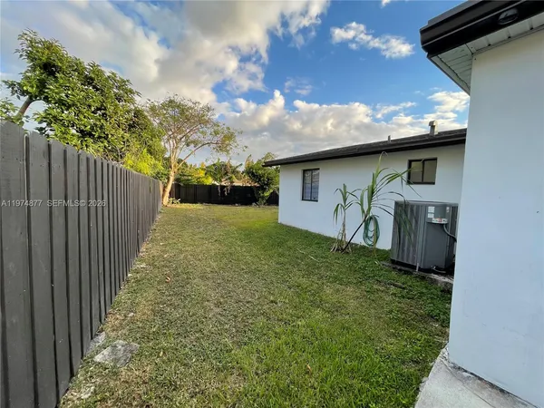 a front view of house with yard and trees in the background