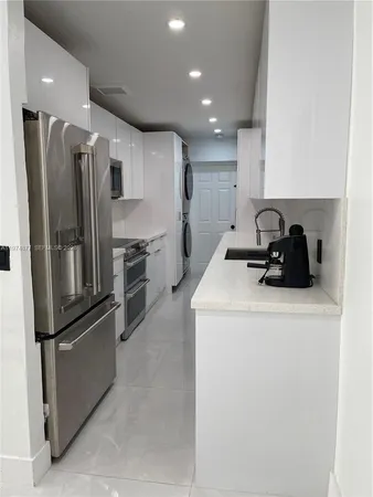 a kitchen with a refrigerator and a stove top oven