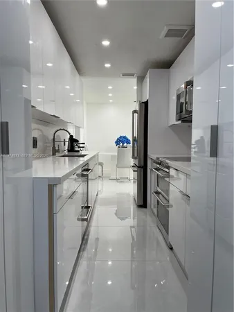 a kitchen with white cabinets and appliances