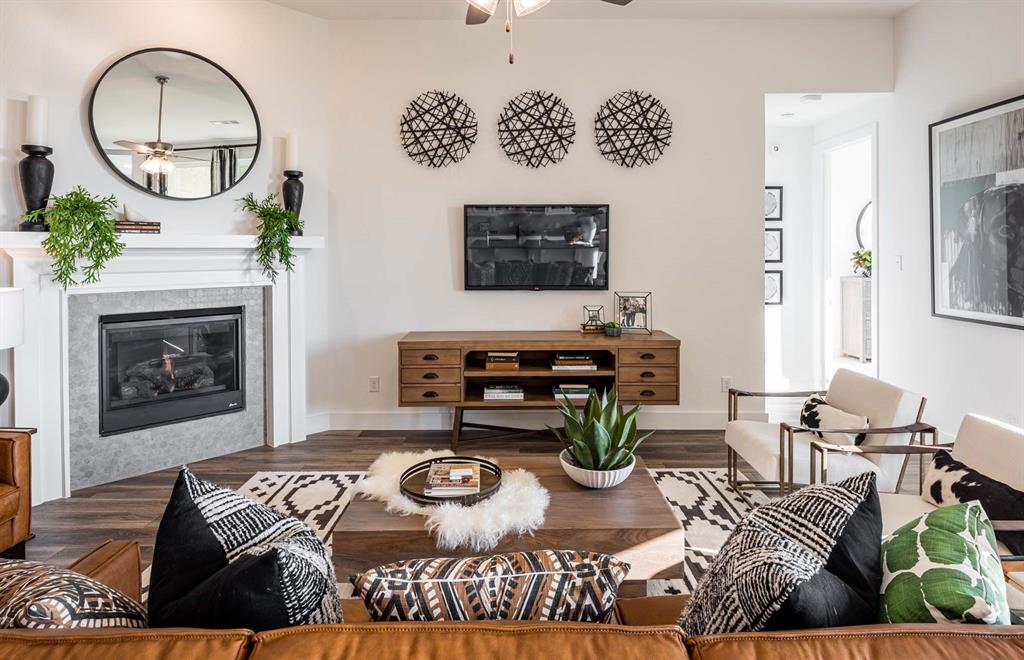 1222 Abbeygreen Road Forney, TX 75126 - Photo 3 of 29 a living room with furniture a clock and a fireplace