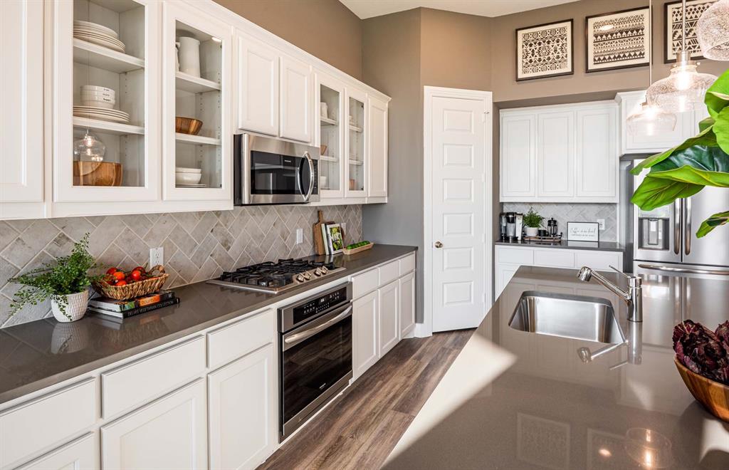 1222 Abbeygreen Road Forney, TX 75126 - Photo 7 of 29 a kitchen with stainless steel appliances granite countertop a sink stove and cabinets