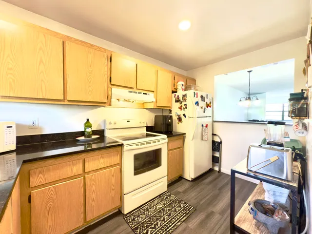 a kitchen with stainless steel appliances granite countertop a stove a sink and a refrigerator