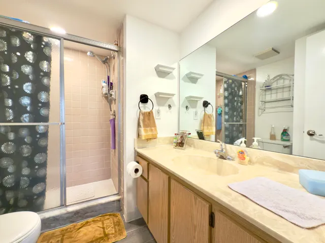 a bathroom with a granite countertop sink mirror and shower