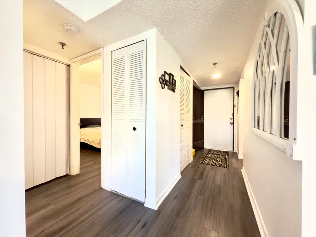 a view of a hallway with wooden floor and staircase