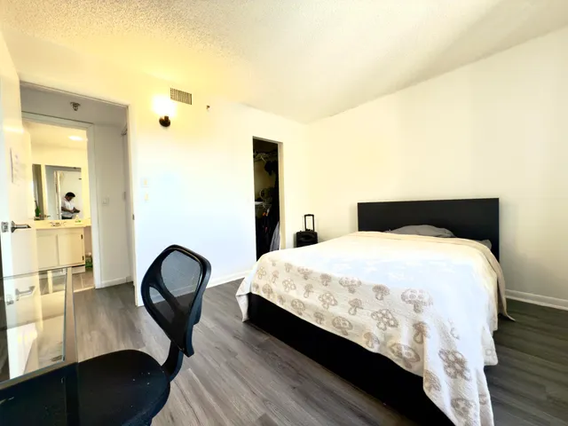 a bedroom with bed and wooden floor