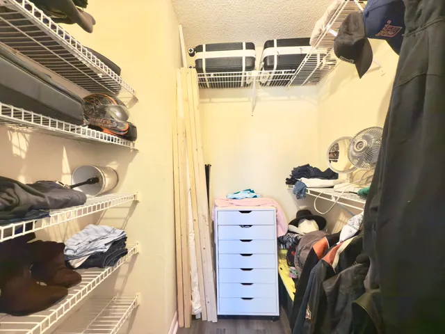 a view of walk in closet with clothes and shoes