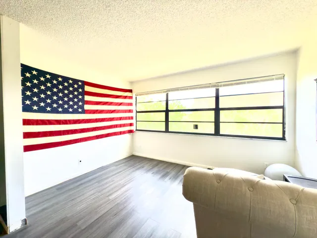 a view of a bedroom with wooden floor and window
