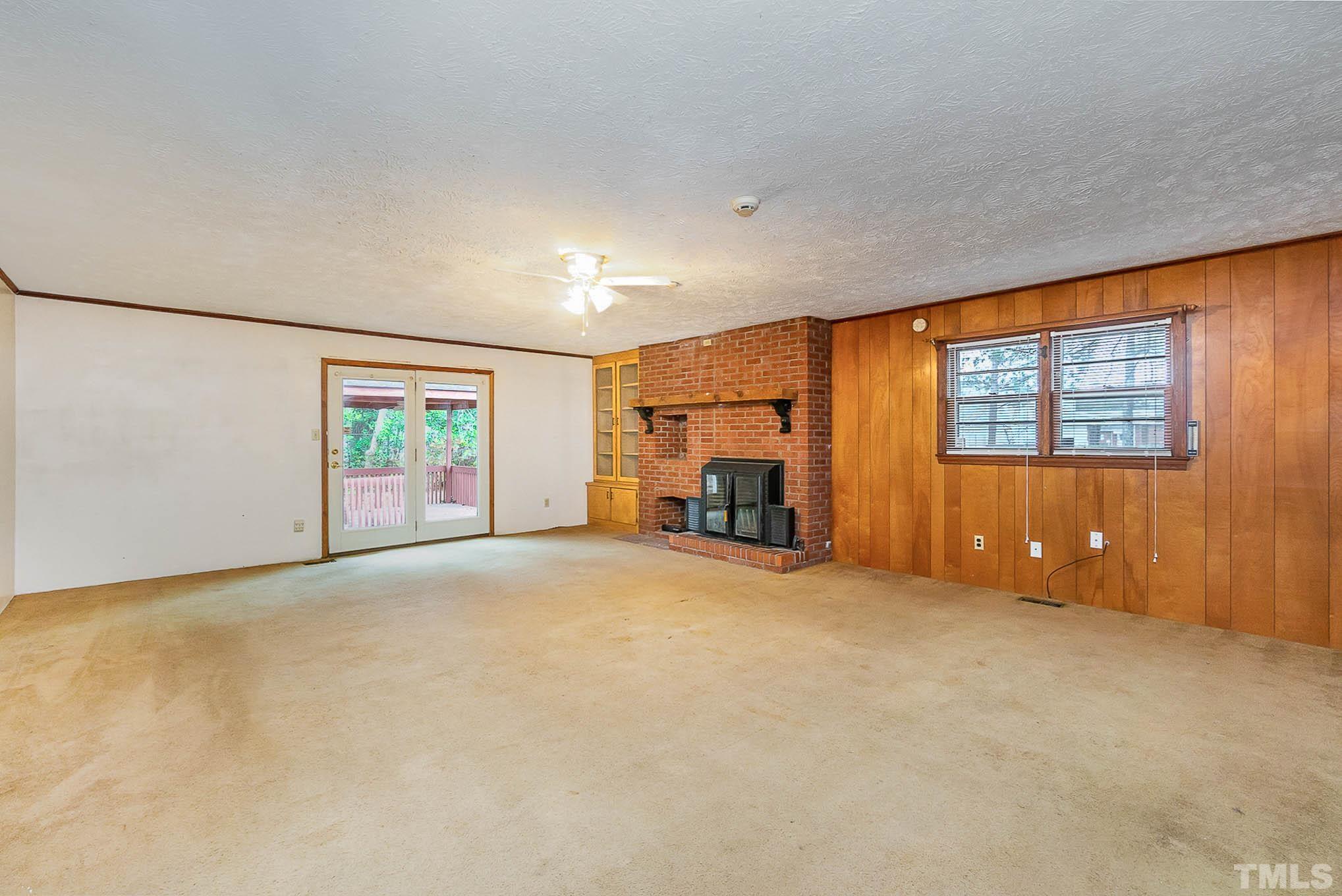 4874 Cameron Road Hope Mills, NC 28348 - Photo 5 of 21 an empty room with a fireplace and windows