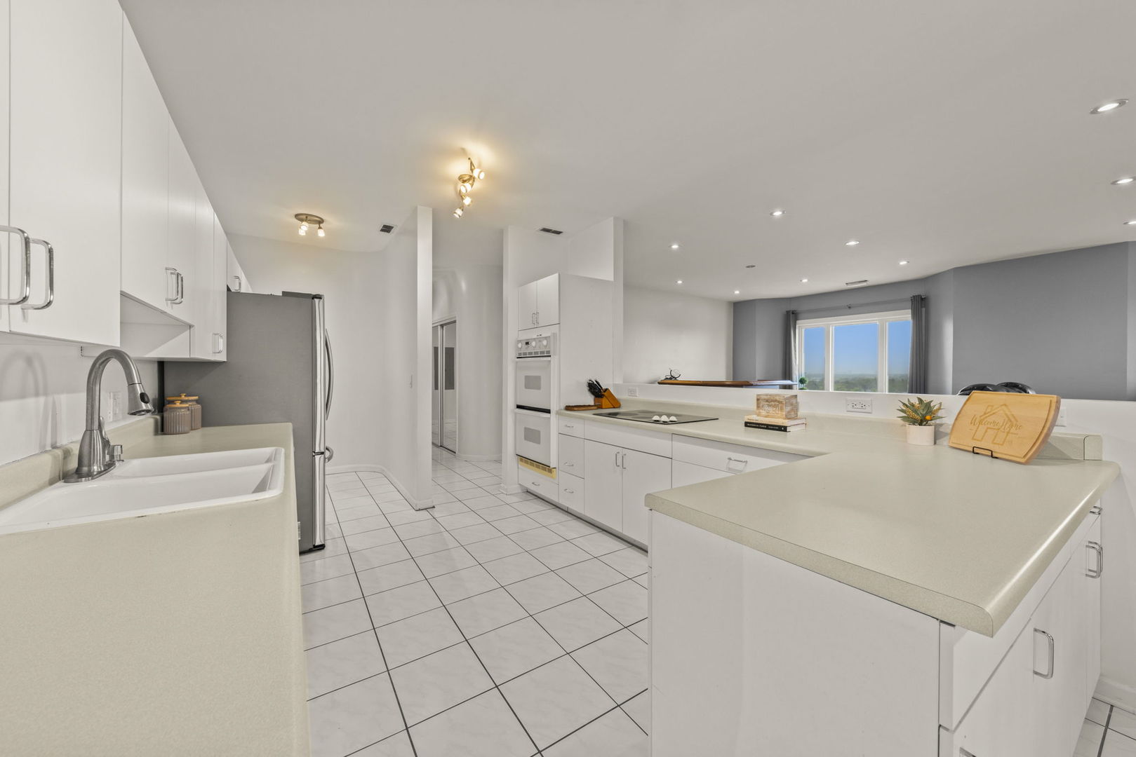 1 Renaissance Place, Unit PH2 Palatine, IL 60067 - Photo 9 of 23 a large white kitchen with a white countertops a stove a dining table and chairs