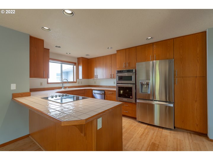 15917 Northeast Union Road, Unit 29 Ridgefield, WA 98642 - Photo 12 of 31 a kitchen with stainless steel appliances granite countertop a sink refrigerator and microwave