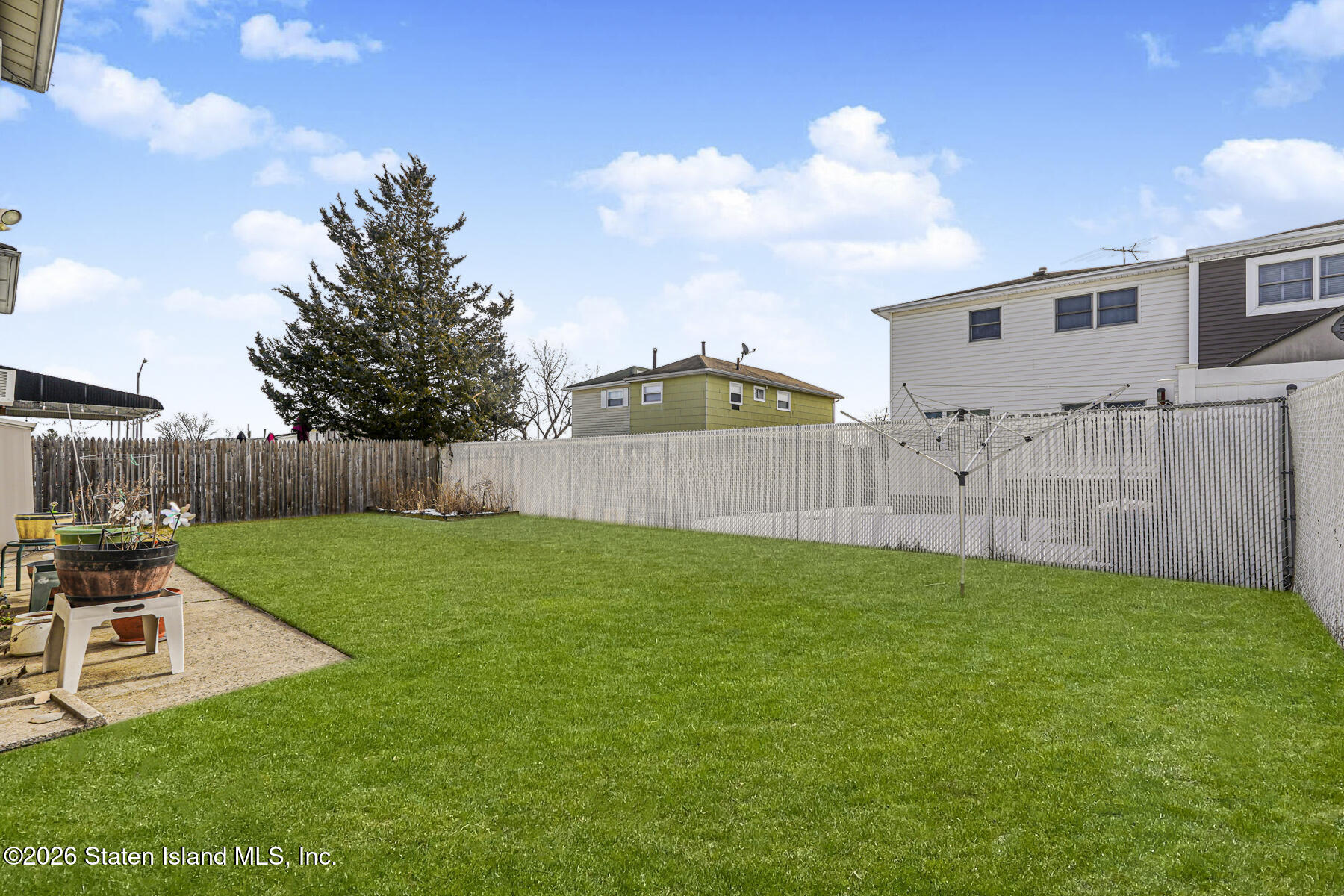 76 Berry Avenue Staten Island, NY 10312 - Photo 36 of 42 a view of a backyard with table and chairs and wooden fence