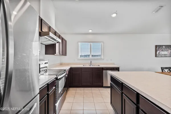 a kitchen with a sink dishwasher a stove and a refrigerator with wooden floor