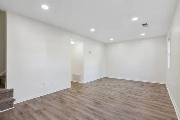 an empty room with wooden floor and entrance