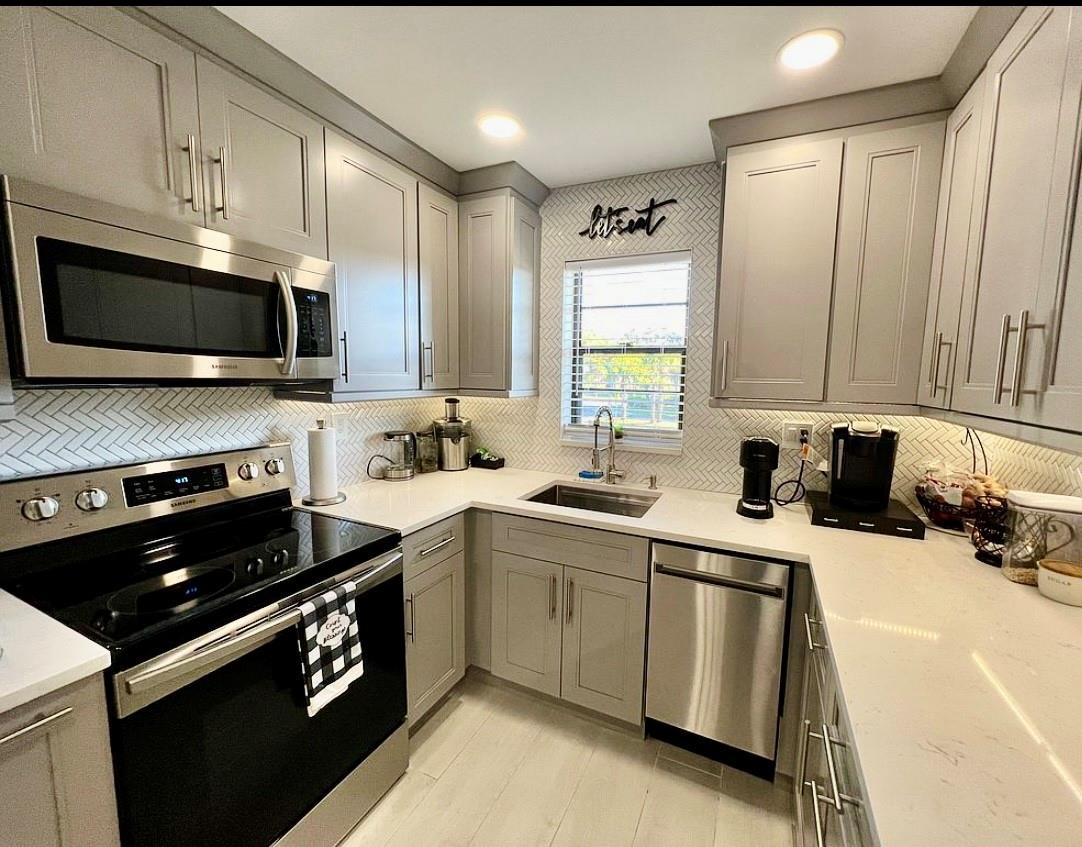 9235 Southwest 8th Street, Unit 207 Boca Raton, FL 33428 - Photo 1 of 24 a kitchen with a sink stove and microwave
