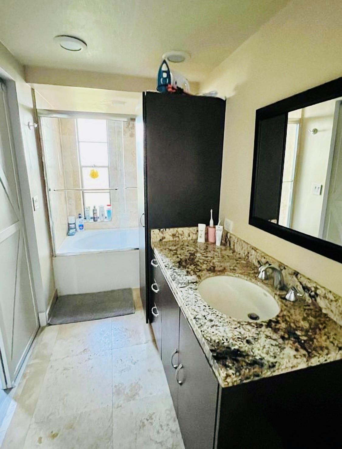 9235 Southwest 8th Street, Unit 207 Boca Raton, FL 33428 - Photo 18 of 24 a bathroom with a granite countertop sink and a mirror