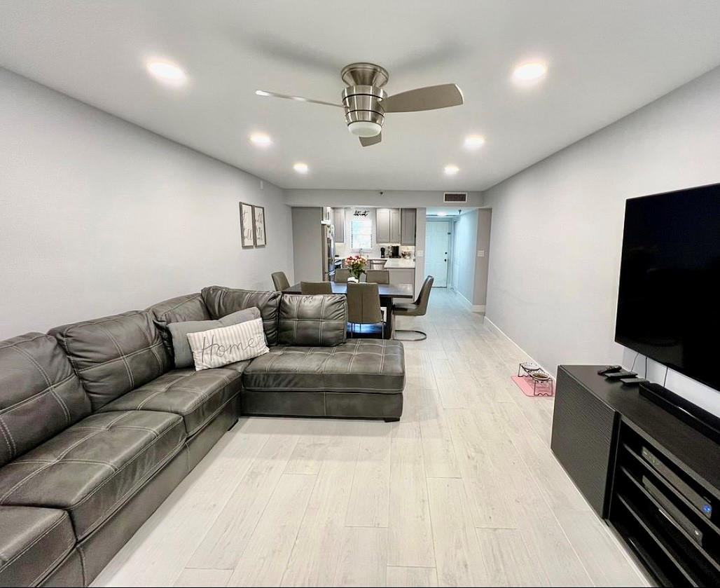 9235 Southwest 8th Street, Unit 207 Boca Raton, FL 33428 - Photo 6 of 24 a living room with furniture and a flat screen tv