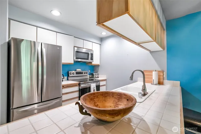 a kitchen with stainless steel appliances a refrigerator and a stove top oven