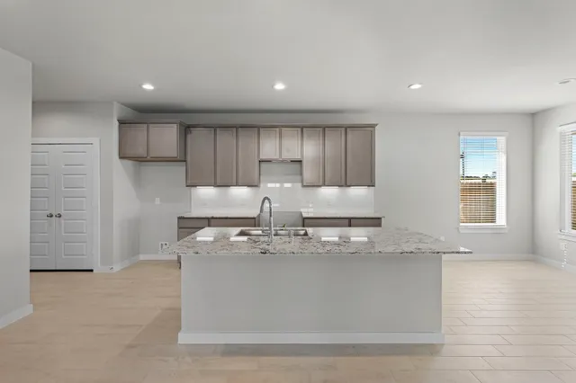 a large kitchen with granite countertop a stove top oven a sink and dishwasher