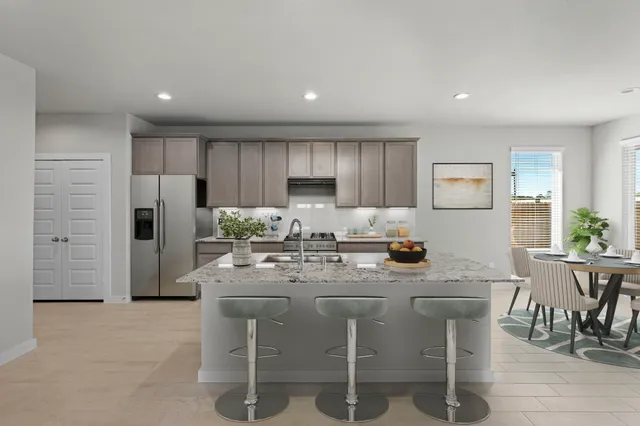 a kitchen with refrigerator and chairs