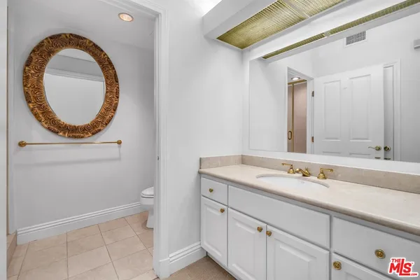 a bathroom with a sink a toilet and a mirror