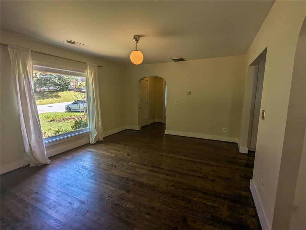 1261 Eastridge Road Southwest Atlanta, GA 30311 - Photo 12 of 36 an empty room with wooden floor and windows