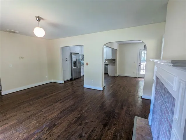 a kitchen with stainless steel appliances granite countertop a refrigerator a sink dishwasher a stove top oven a refrigerator with wooden floors