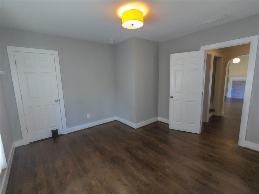 1261 Eastridge Road Southwest Atlanta, GA 30311 - Photo 17 of 36 an empty room with wooden floor and window