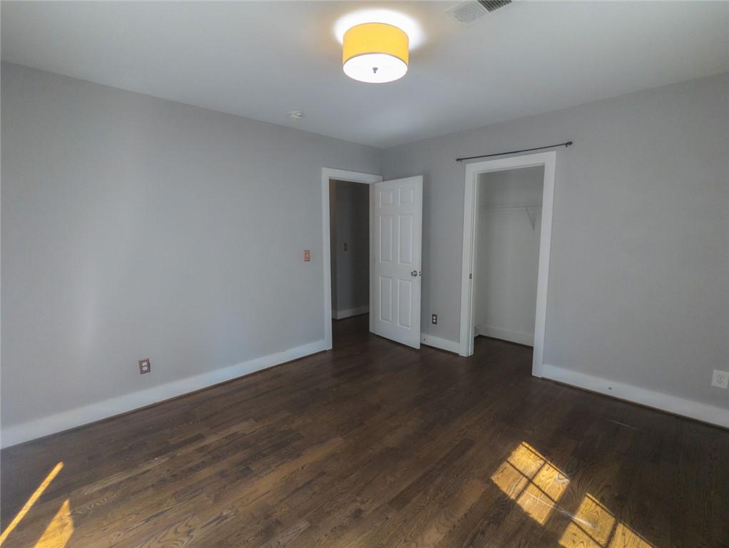 1261 Eastridge Road Southwest Atlanta, GA 30311 - Photo 18 of 36 an empty room with wooden floor and windows