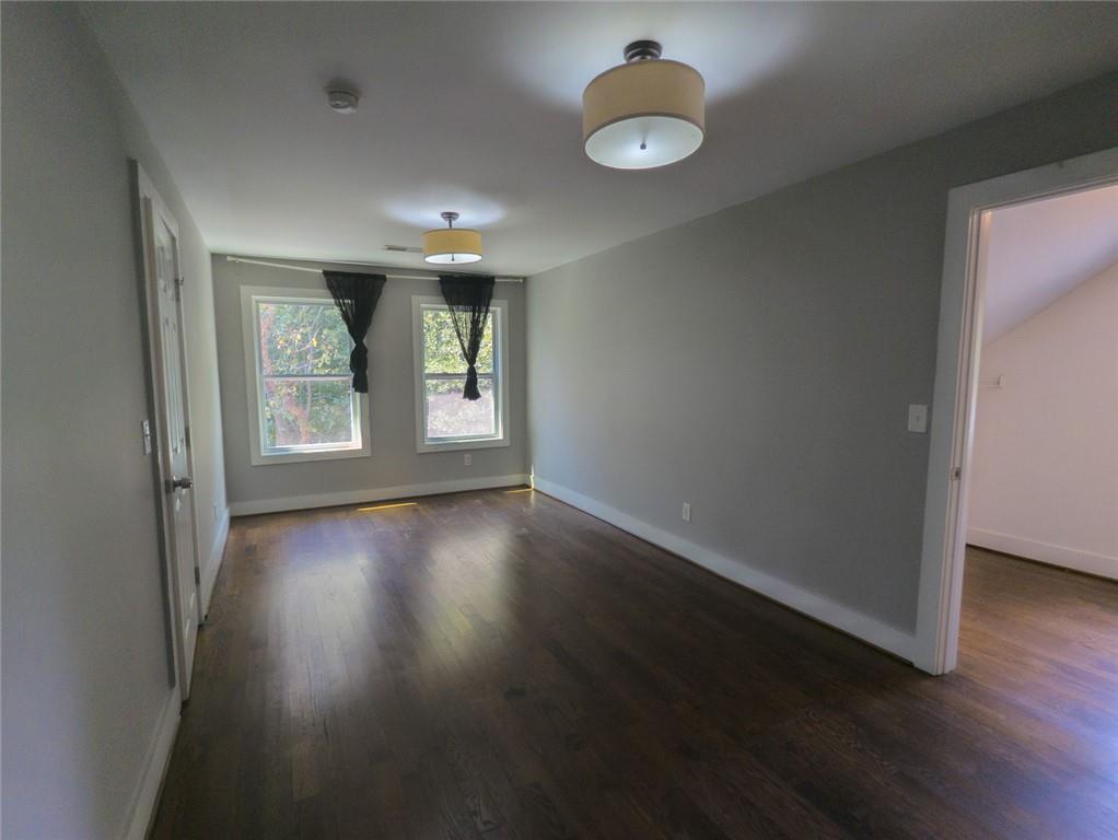1261 Eastridge Road Southwest Atlanta, GA 30311 - Photo 19 of 36 an empty room with wooden floor and windows