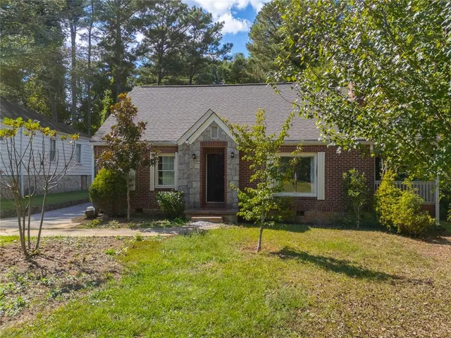 a view of a house with a yard and tree s
