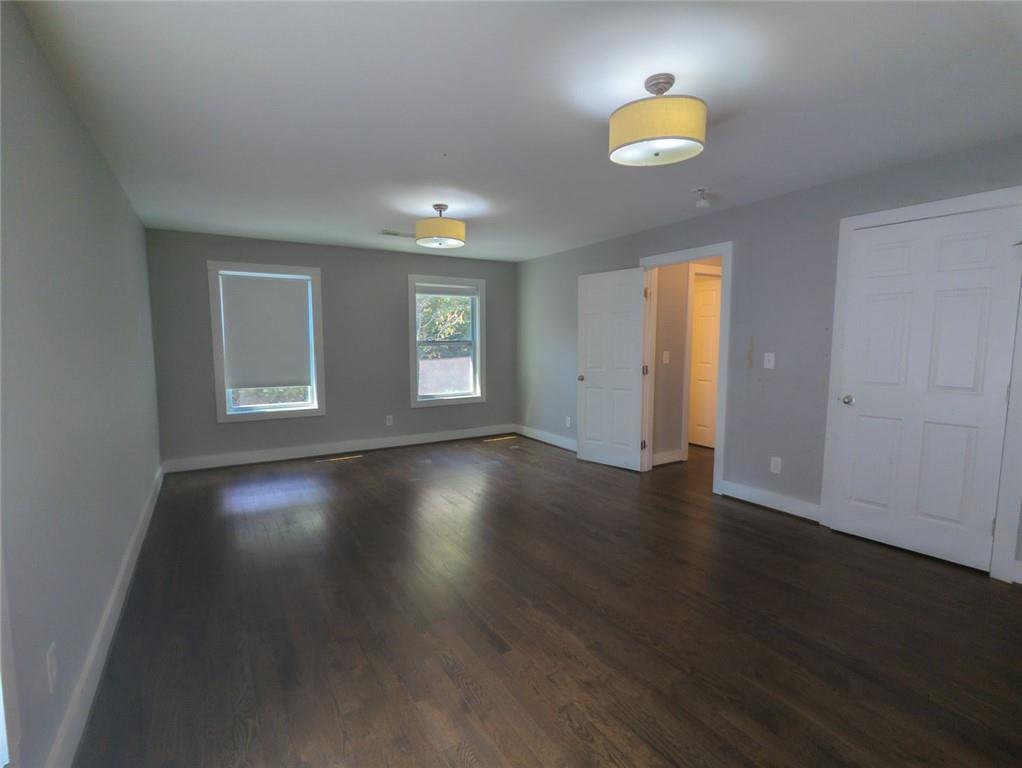 1261 Eastridge Road Southwest Atlanta, GA 30311 - Photo 23 of 36 an empty room with wooden floor and windows