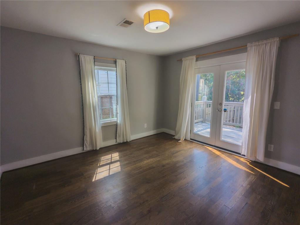 1261 Eastridge Road Southwest Atlanta, GA 30311 - Photo 24 of 36 an empty room with wooden floor and windows