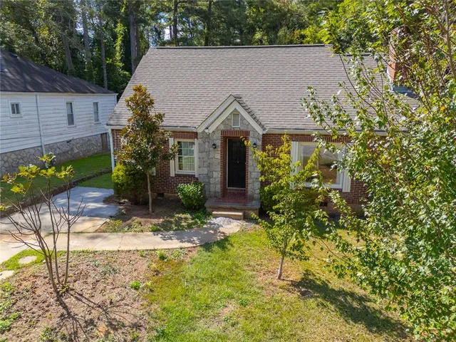a view of house with yard and sitting area