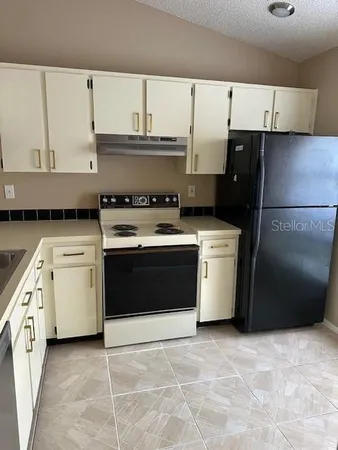 a kitchen with a stove top oven sink and cabinets