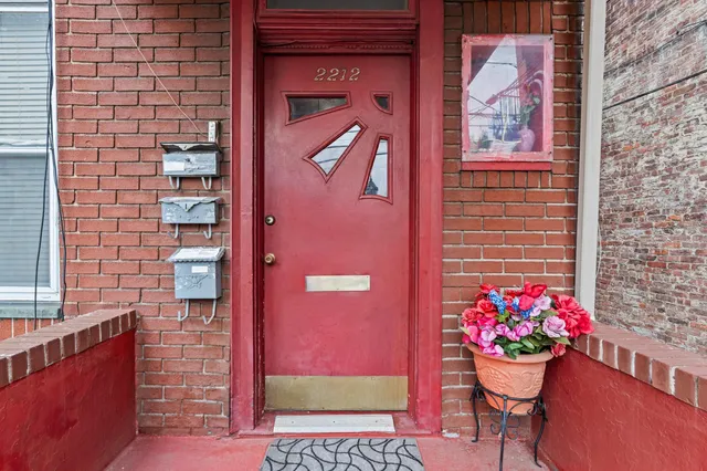 a front view of a house with a potted plant and a bench