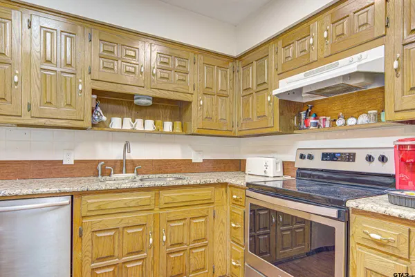 a kitchen with stainless steel appliances granite countertop a sink and cabinets