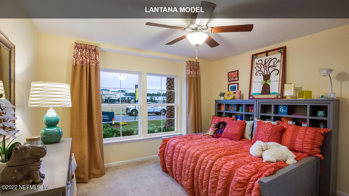 65784 Edgewater Drive Yulee, FL 32097 - Photo 12 of 44 a bed room with a bed and a chandelier