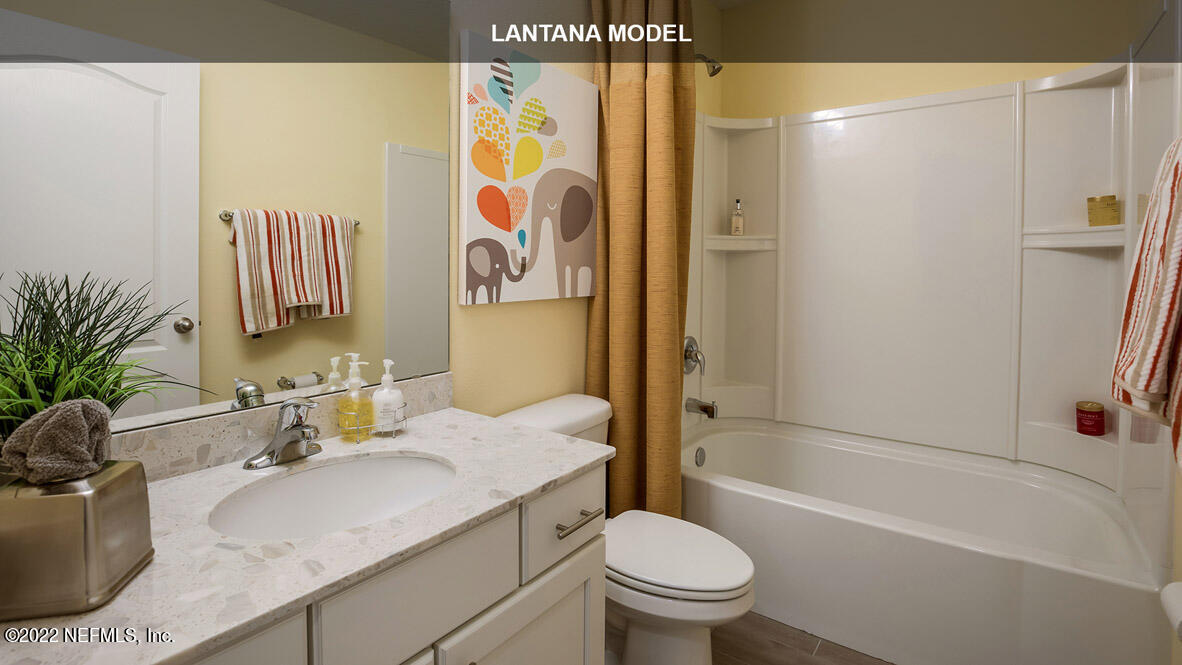 65784 Edgewater Drive Yulee, FL 32097 - Photo 13 of 44 a bathroom with a granite countertop sink a toilet and shower