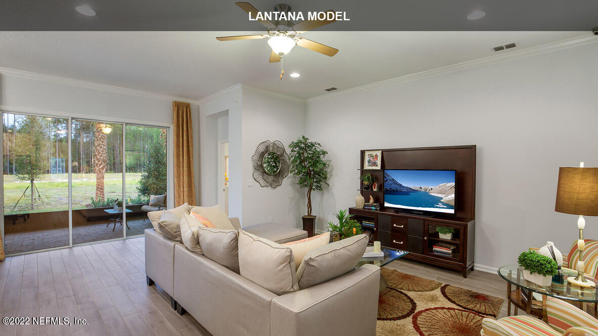 65784 Edgewater Drive Yulee, FL 32097 - Photo 7 of 44 a living room with furniture a flat screen tv and a floor to ceiling window