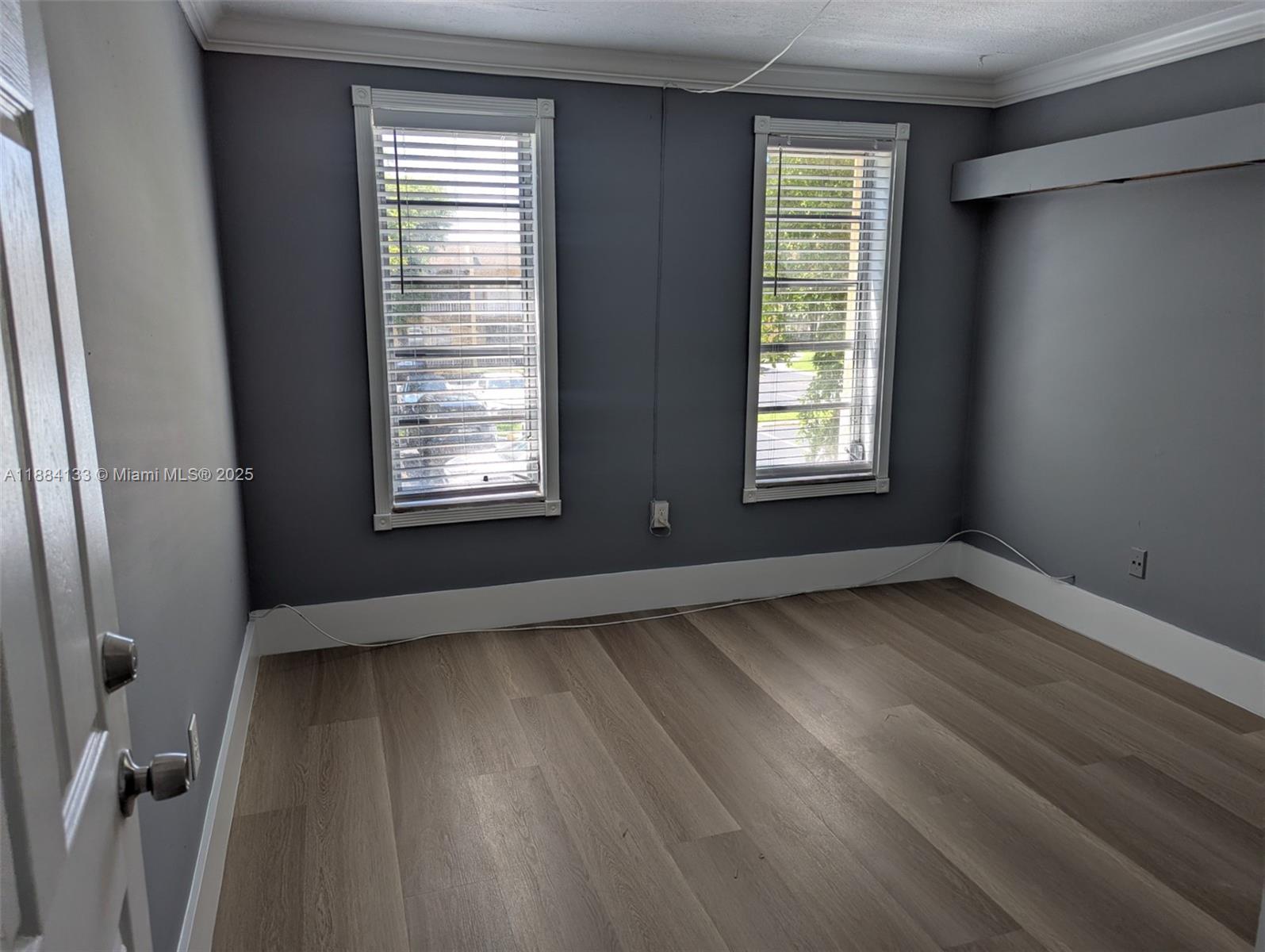 13700 Southwest 62nd Street, Unit 204 Miami, FL 33183 - Photo 12 of 30 a view of an empty room with wooden floor and a window