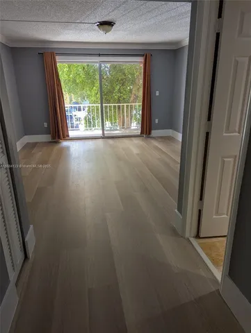an empty room with wooden floor and a window