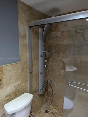 a white toilet sitting next to a bath tub and shower