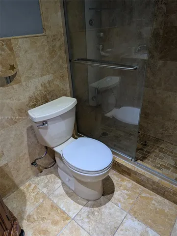 a bathroom with a toilet and a shower