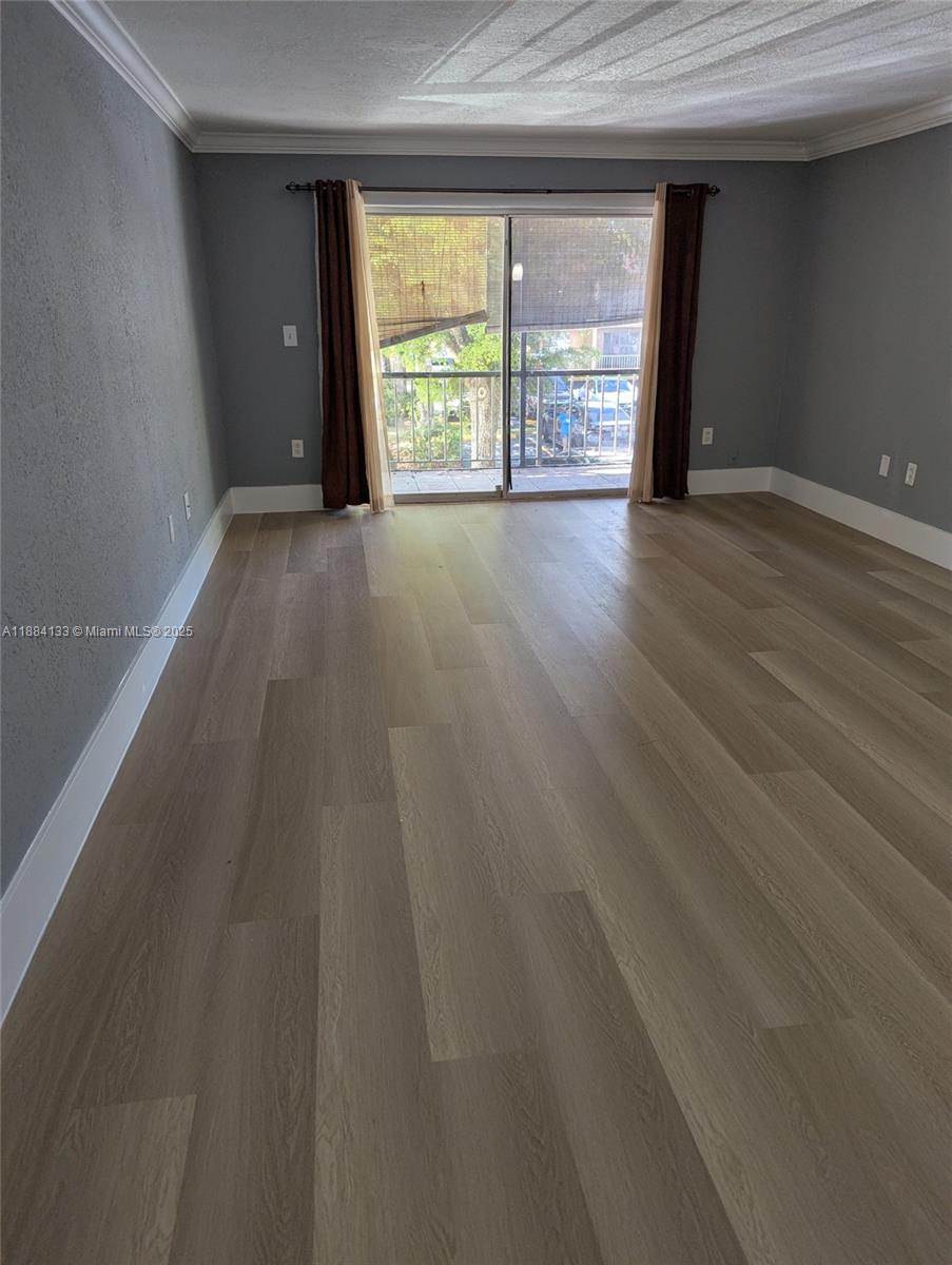13700 Southwest 62nd Street, Unit 204 Miami, FL 33183 - Photo 5 of 30 a view of an empty room with wooden floor and a window